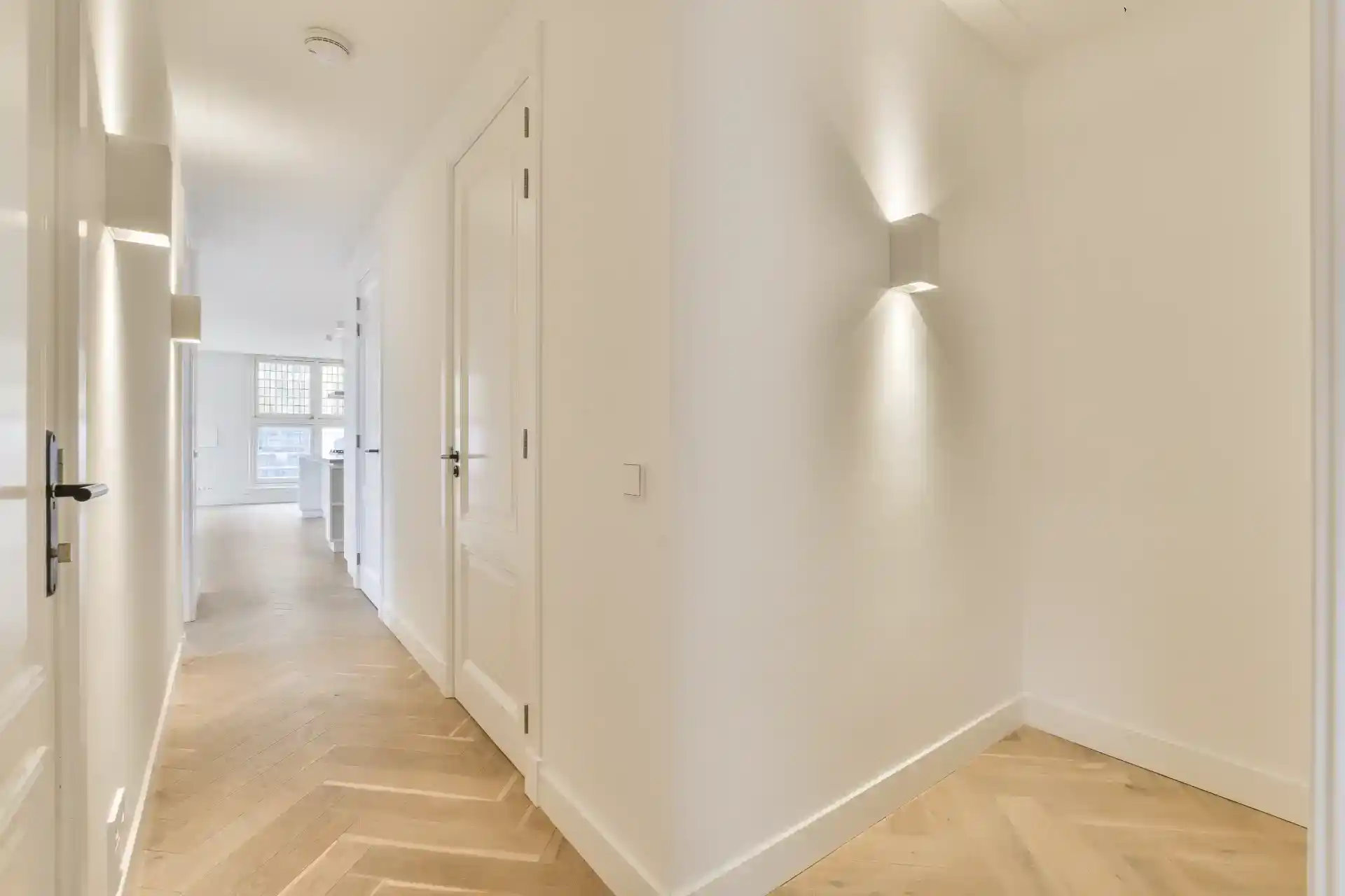 Hvidt indreaced, indbydende bolig med moderne belysning og elegant trægulv.