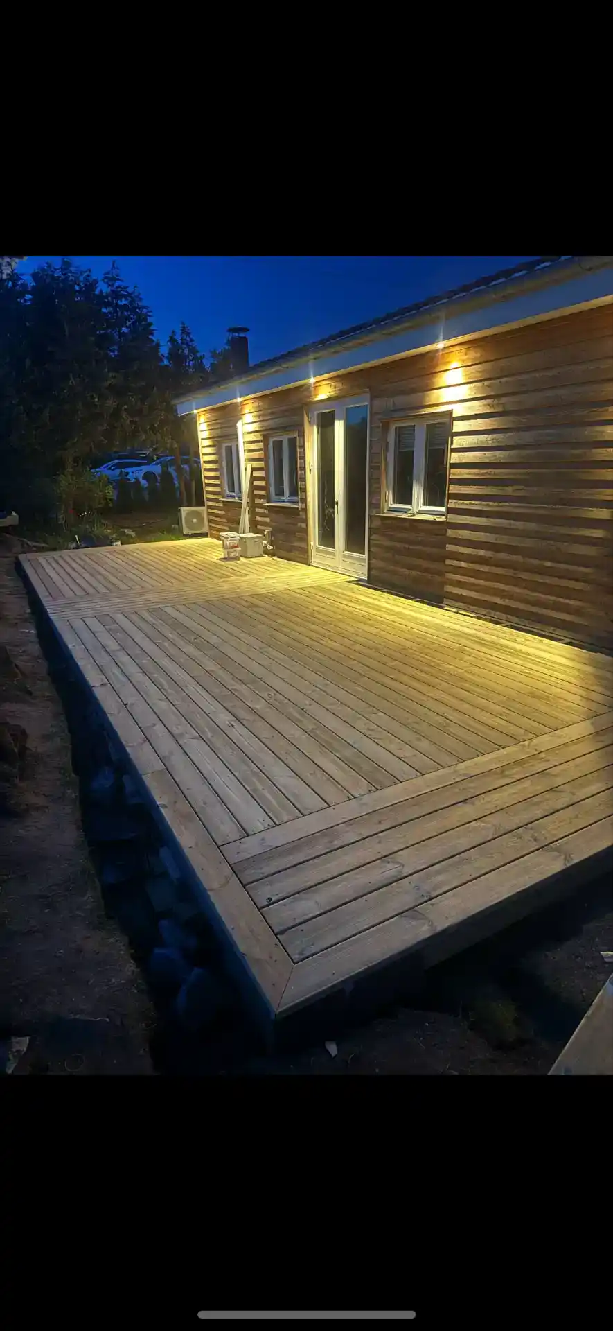 Havedækning med træmateriale og udendørs belysning.