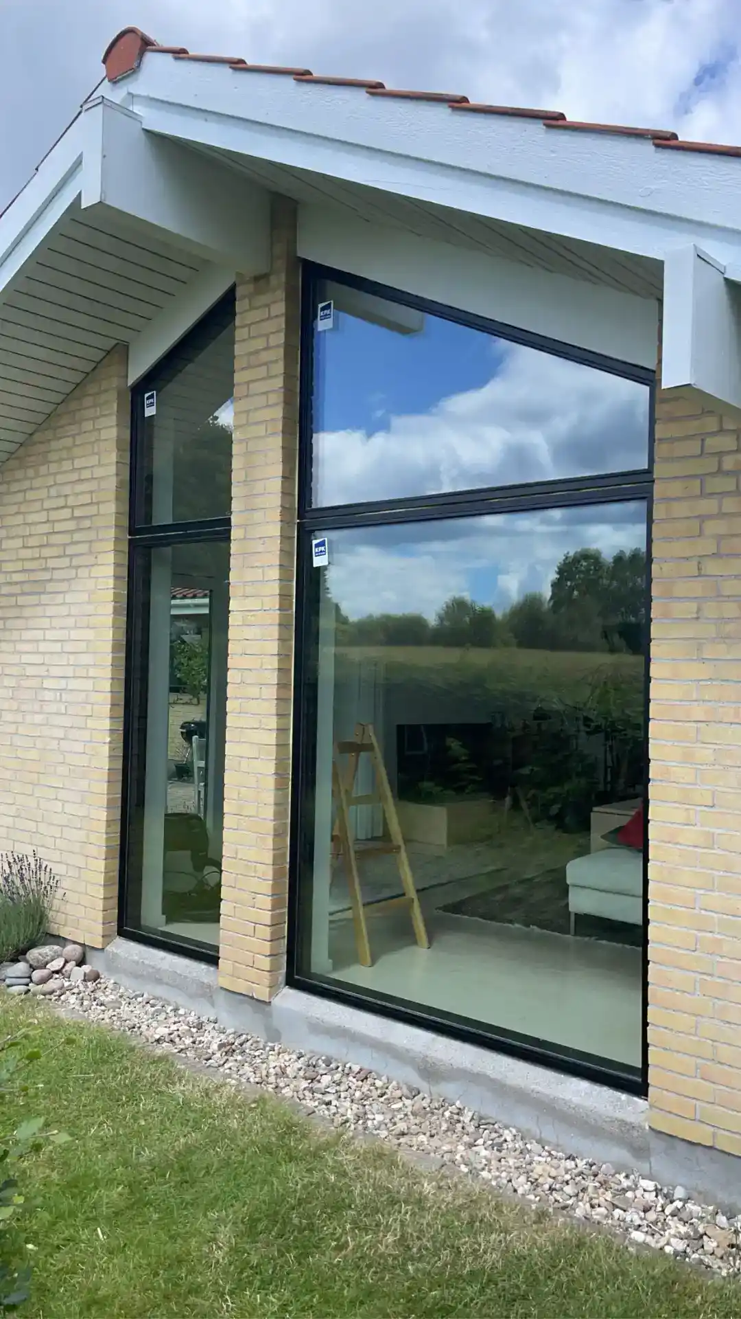 1. Moderne vinduesparti med sort aluminiumsrammer og reflekterende glas.