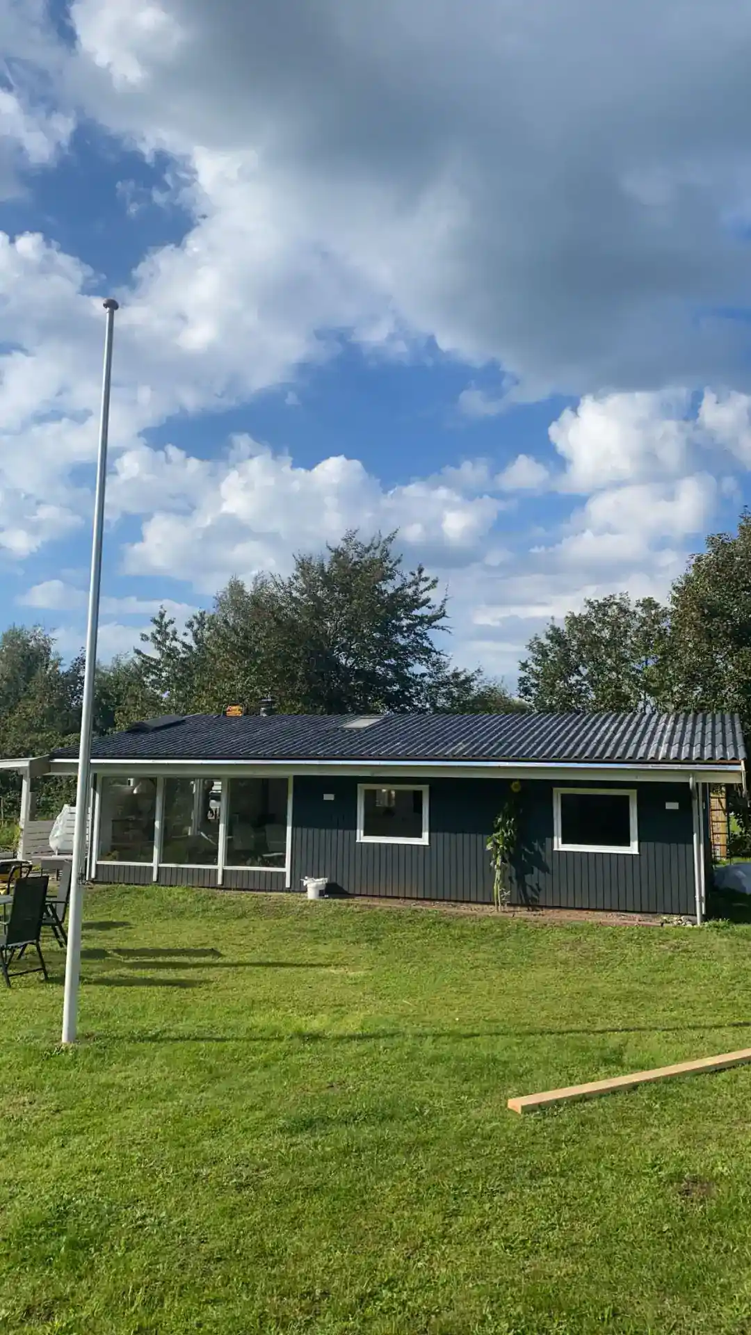 1. Moderne hus med græsplæne under blå himmel og skyer.