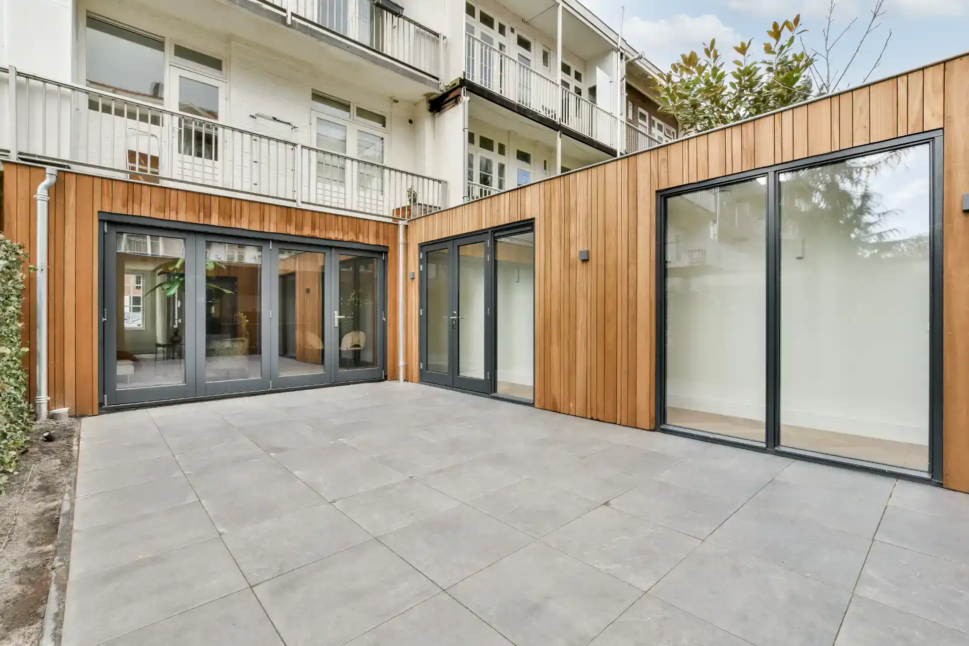 Elegant træaltandørs skydedøre i moderne terrassedesign.