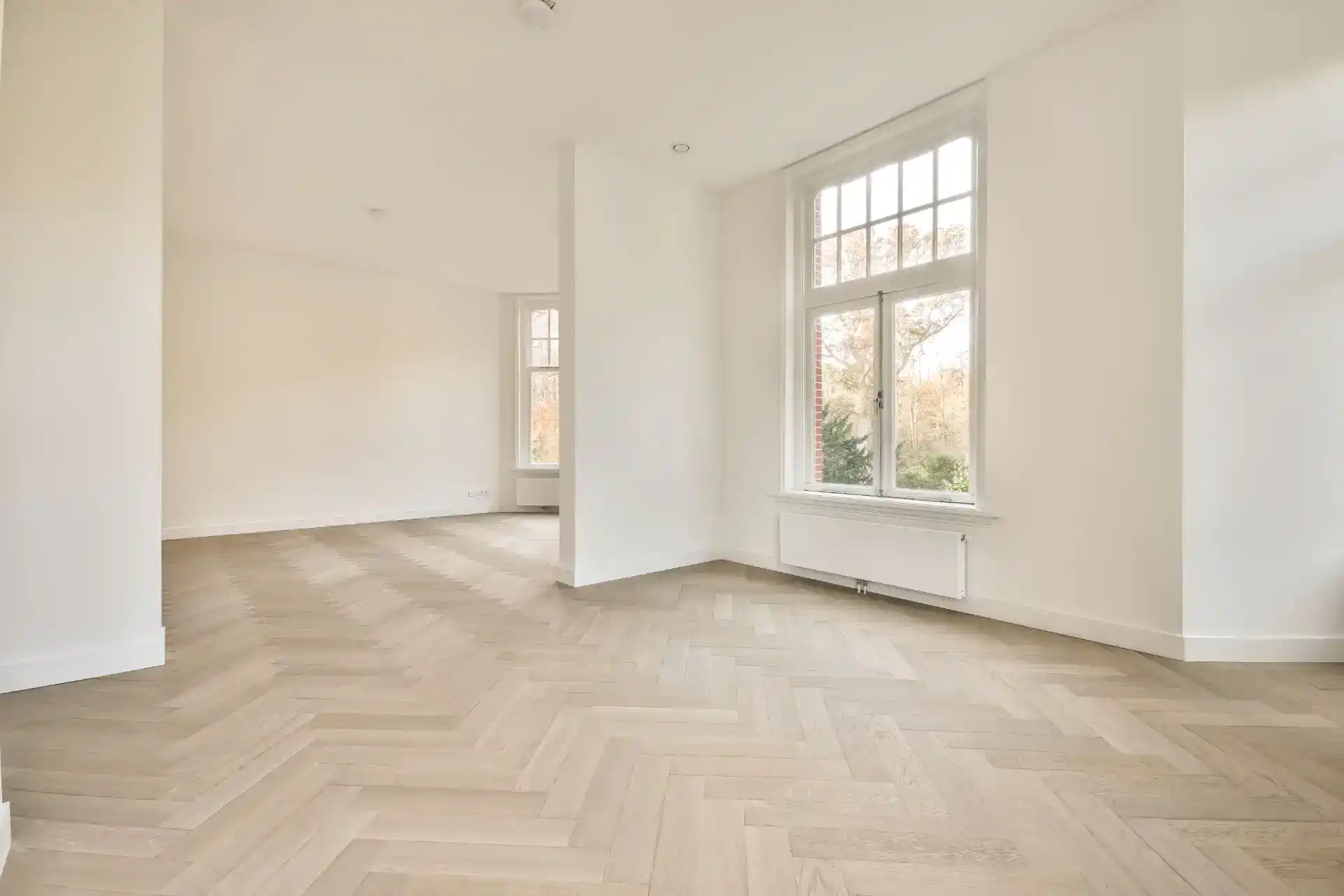 Malerarbejde og nye trægulve i moderne boligrum.