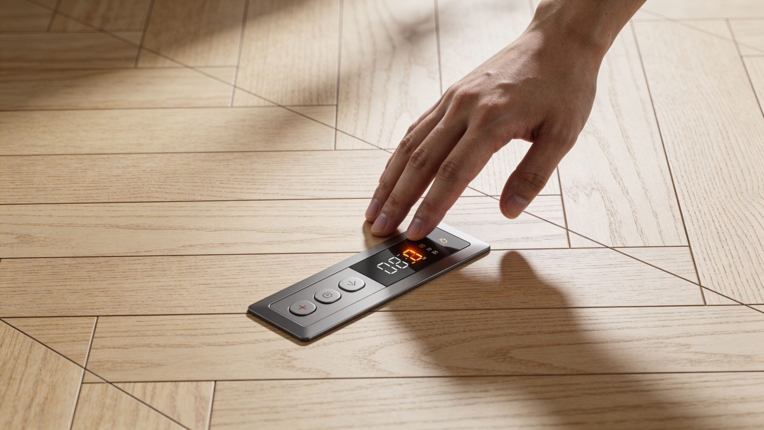 En hånd justerer temperaturen på et digitalt gulvvarmepanel installeret direkte i et flot lyst trægulv.